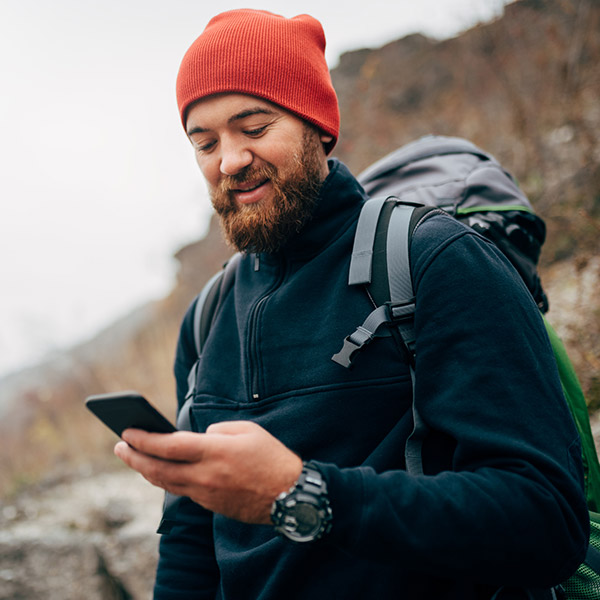 Traveler bearded man in red hat using mobile phone application
